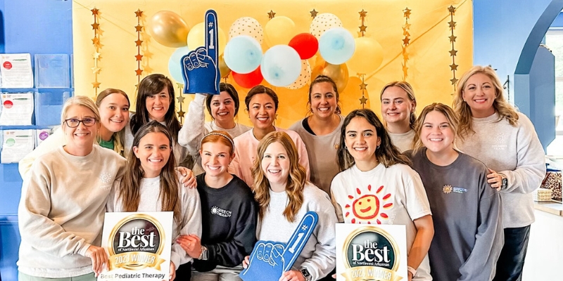 Speech Therapist smile with #1 foam fingers celebrating winning the Best of NWA Award